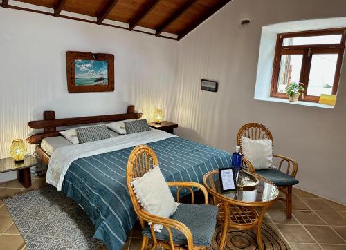 a bedroom with a bed and a table and chairs at Finca mit Meerblick und Jacuzzi in Las Cruces