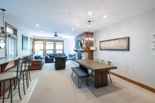 a dining room and living room with a table and chairs at Les Eaux Tremblant - Luxury Chalet with Pool & Spa and AC in Mont-Tremblant