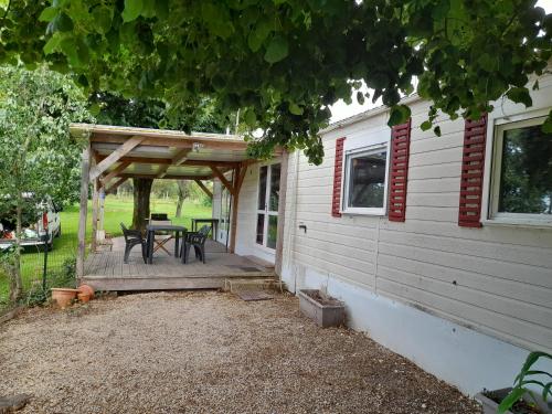- une terrasse avec une table et un auvent à côté d'une maison dans l'établissement Mobil home en pleine campagne, à Bardenac
