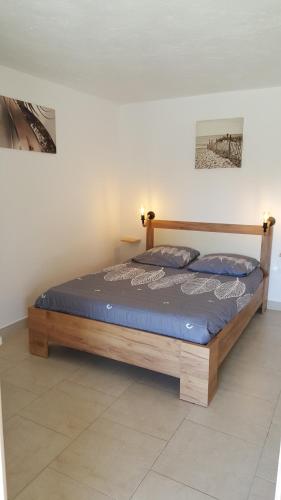 Ce lit se trouve dans un dortoir doté d'un cadre en bois. dans l'établissement Mas de la berlusiere, à Saint-André-de-Cruzières