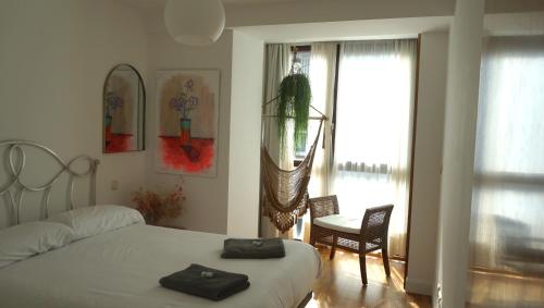 a bedroom with a bed and a chair and a window at Arma Plaza by Basquelidays in Hondarribia