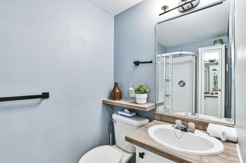 a bathroom with a sink and a toilet and a mirror at Aiglon by Rendez-Vous Mont-Tremblant in Mont-Tremblant
