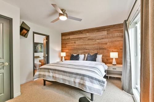 a bedroom with a large bed with a wooden headboard at Aiglon by Rendez-Vous Mont-Tremblant in Mont-Tremblant