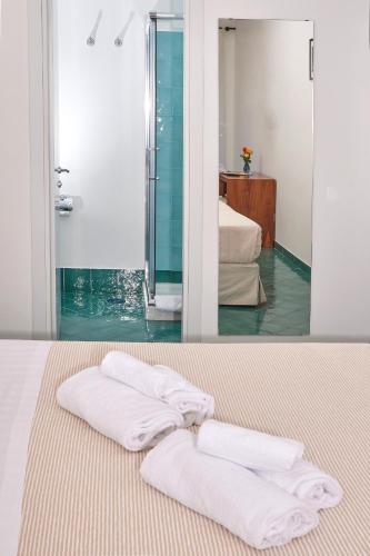 two towels are sitting on a bed in a bathroom at Hotel Victoria Place in Anacapri