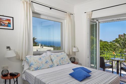 a bedroom with a bed and a large window at Hotel Victoria Place in Anacapri