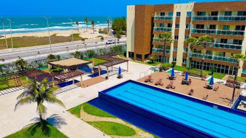 an aerial view of a resort with a swimming pool and the beach at Vg Fun by Diego Flats in Fortaleza