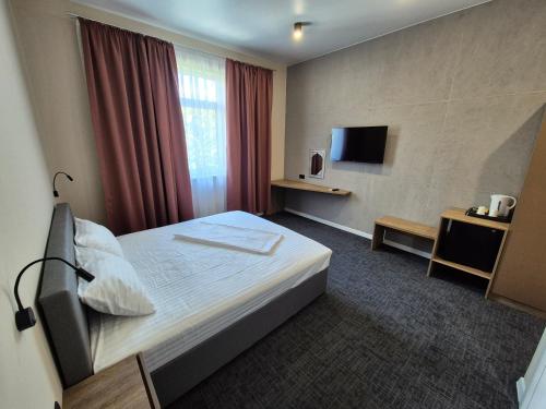 a hotel room with a bed and a television at SEAPOINT Boutique Hotel in Eforie Sud