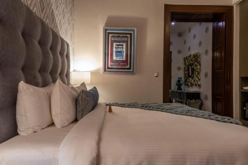 a bedroom with a large bed with white pillows at 1850 Hotel Boutique in Guanajuato