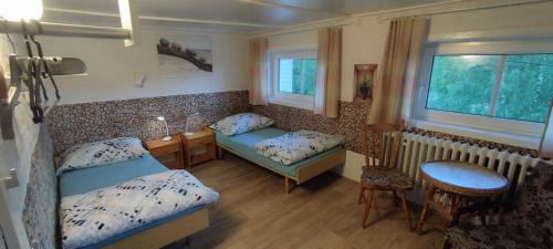 a room with two beds and a table and a window at Pension Panorama in Tanvald