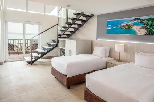 two beds in a room with a staircase at Decameron Galeon - All Inclusive in Santa Marta