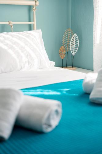 a bedroom with a bed with white sheets and a fan at Sitholia Apartment Vatopedi in Vatopedi