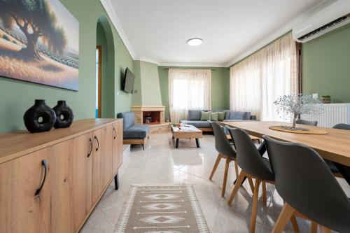 a living room with a table and chairs and a couch at Sitholia Apartment Vatopedi in Vatopedi