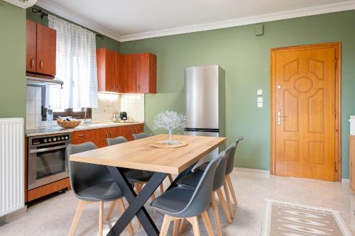 a kitchen with a wooden table and chairs at Sitholia Apartment Vatopedi in Vatopedi