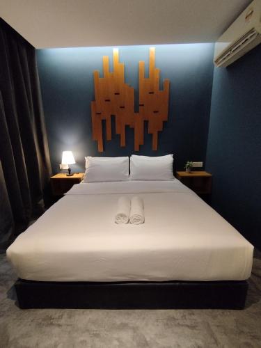 a bedroom with a bed with two white shoes on it at Kingston Hotel 7 - Johor Bharu in Johor Bahru