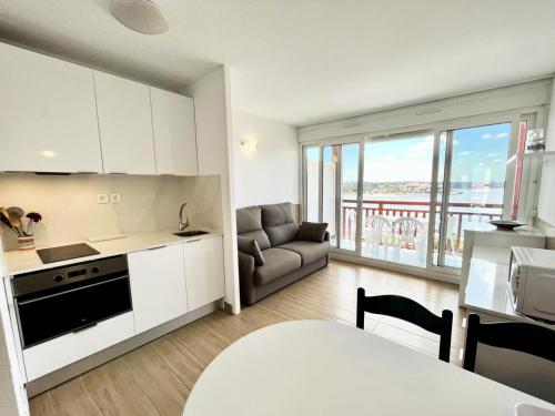une cuisine et un salon avec un canapé et une table dans l'établissement Résidence Le Boucanier - 2 Pièces pour 4 Personnes 004, à Vieux-Boucau-les-Bains
