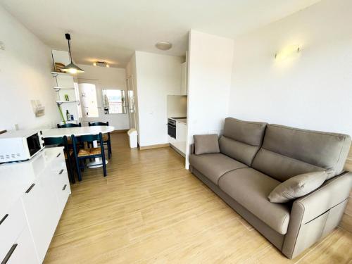 un salon avec un canapé et une cuisine dans l'établissement Résidence Le Boucanier - 2 Pièces pour 4 Personnes 004, à Vieux-Boucau-les-Bains