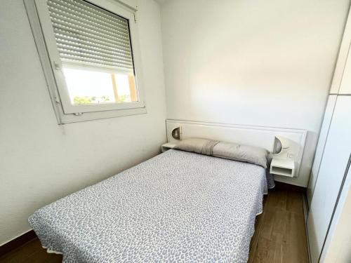 une petite chambre avec un lit et une fenêtre dans l'établissement Résidence Le Boucanier - 2 Pièces pour 4 Personnes 004, à Vieux-Boucau-les-Bains