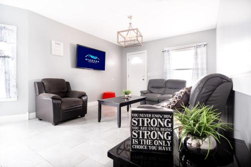 a living room with two chairs and a couch at Comfy 4BR, 1 Bath Near the Falls & Casino in Niagara Falls