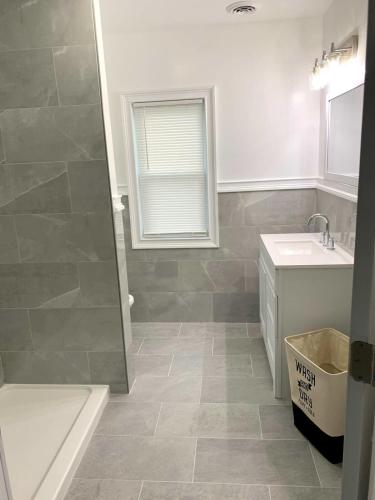 a bathroom with a shower and a sink and a tub at Comfy 4BR, 1 Bath Near the Falls & Casino in Niagara Falls