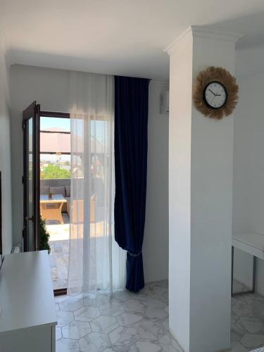a room with a window with a clock on the wall at Penthouse Sea Breeze in K'obulet'i