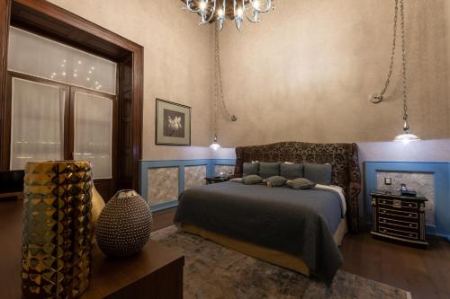 a bedroom with a bed and a chandelier at 1850 Hotel Boutique in Guanajuato
