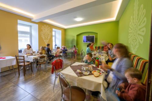 a group of people sitting at tables in a restaurant at Penzión Antiqua Villa in Spišská Stará Ves