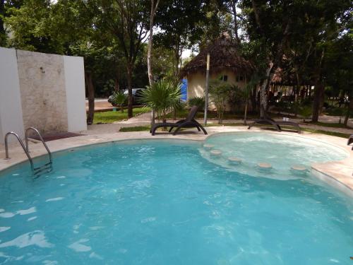 a large swimming pool with chairs in a yard at 2 BR-house in Puerto Morelos with stunning view in Puerto Morelos