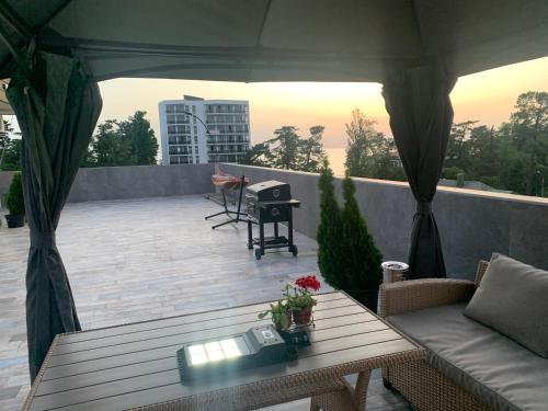 a patio with a couch and a table on a roof at Penthouse Sea Breeze in K'obulet'i