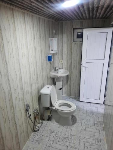 a bathroom with a toilet and a sink and a door at Ilisu House in Qax