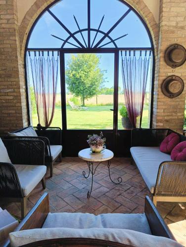 a living room with a large window and a table at B&B Casa del Bosco in San Michele al Tagliamento