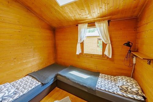 a bed in a log cabin with a window at Domki nad Odrą Wały in Brzeg Dolny