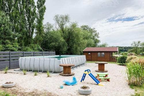 a backyard with a swimming pool and a playground at Domki nad Odrą Wały in Brzeg Dolny