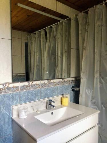 a bathroom with a sink and a mirror at Casa da Avó Clotilde in São Roque do Pico