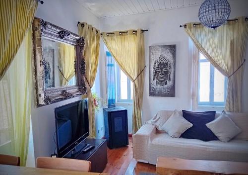 a living room with a couch and a television at The Corner House - Charming Rustic Home in the Heart of Monchique in Monchique