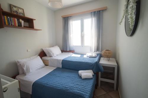 a small bedroom with two beds and a window at Luxury Beach Villa in Skála