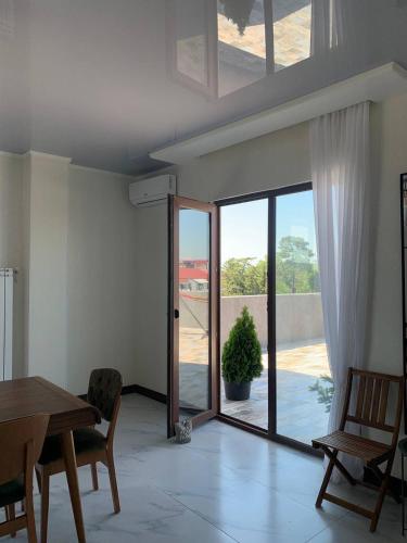 a living room with a table and a sliding glass door at Penthouse Sea Breeze in K'obulet'i