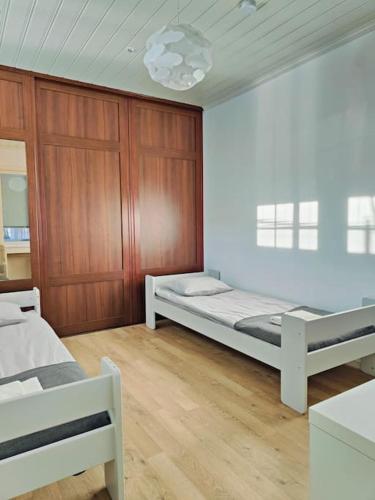 a bedroom with two beds and a wooden wall at The Sunny Villa in Kokkola