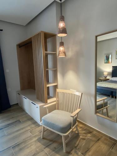 a bedroom with a chair and a mirror and a bed at 180 Pool Villa in Anavissos