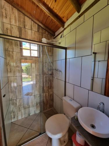 a bathroom with a toilet and a sink at Chalés Vila Carrancas - Ao lado do centro com piscina, cozinha completa e muita tranquilidade in Carrancas