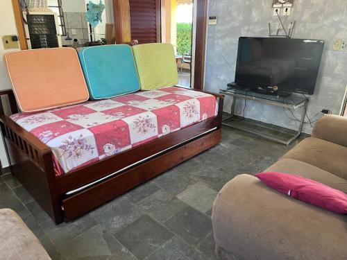 a living room with a couch and a tv at Chácara para Temporada Pai e Filhos in Sao Jose do Rio Preto