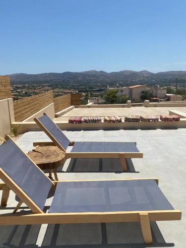 a group of chairs and tables on a roof at 180 Pool Villa in Anavissos