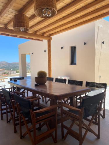 a dining room with a wooden table and chairs at 180 Pool Villa in Anavissos