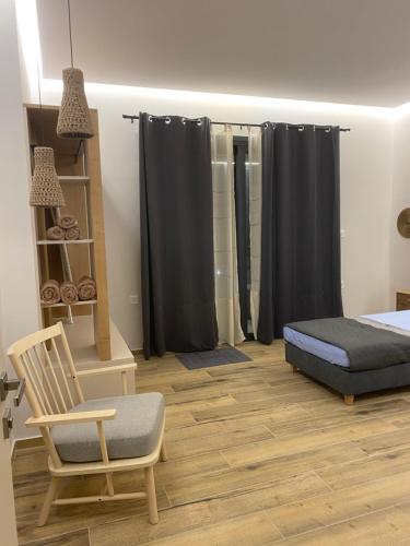 a bedroom with a bed and a chair at 180 Pool Villa in Anavissos