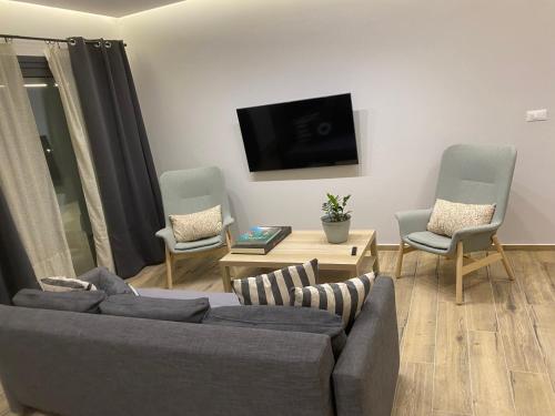 a living room with a couch and two chairs at 180 Pool Villa in Anavissos