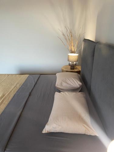 a bed in a room with two pillows on it at 180 Pool Villa in Anavissos