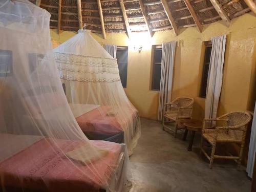 a bedroom with a bed with a mosquito net at Heritage Safari Lodge in Pakwach East