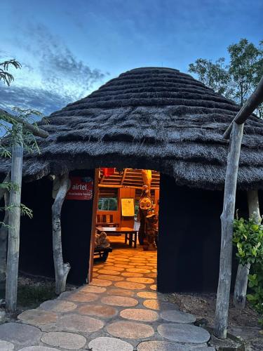 a hut with a thatched roof with a bench in it at Heritage Safari Lodge in Pakwach East
