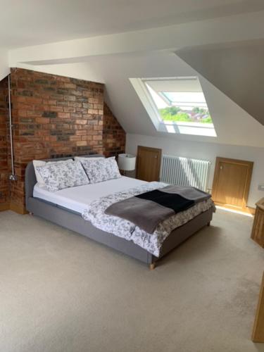 a bedroom with a large bed with a window at 4 Bedroom house with parking, Near Safari Park in Kidderminster