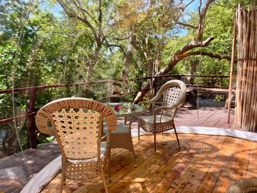 a patio with chairs and a table on a deck at Rock and Sea Resort in Watamu