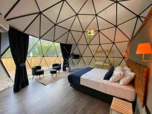 a bedroom with a large room with a bed and a large window at Evaland Glamping in Ardeşen